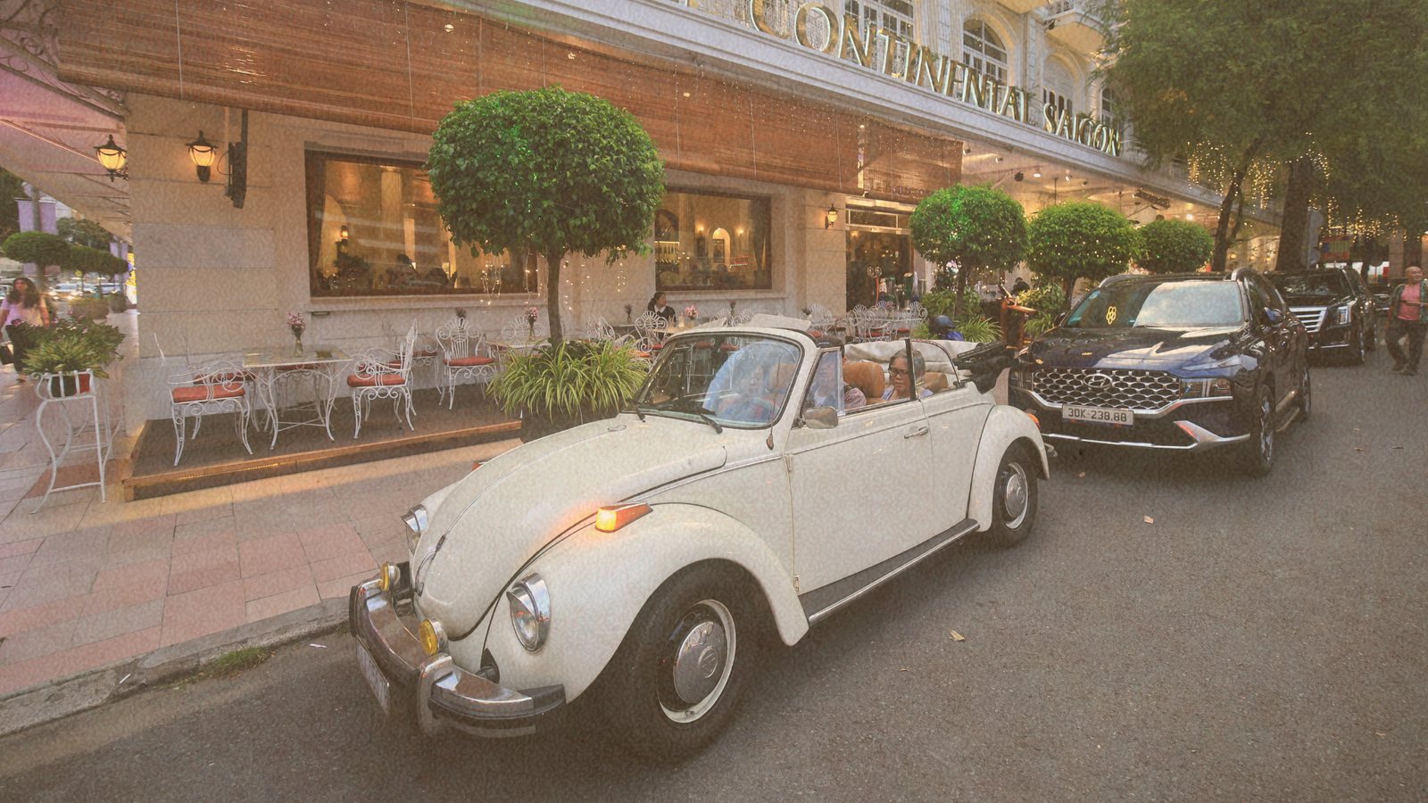 VW Beetle mui trần đỗ trước Hotel Continental Saigon lúc Chiều tà